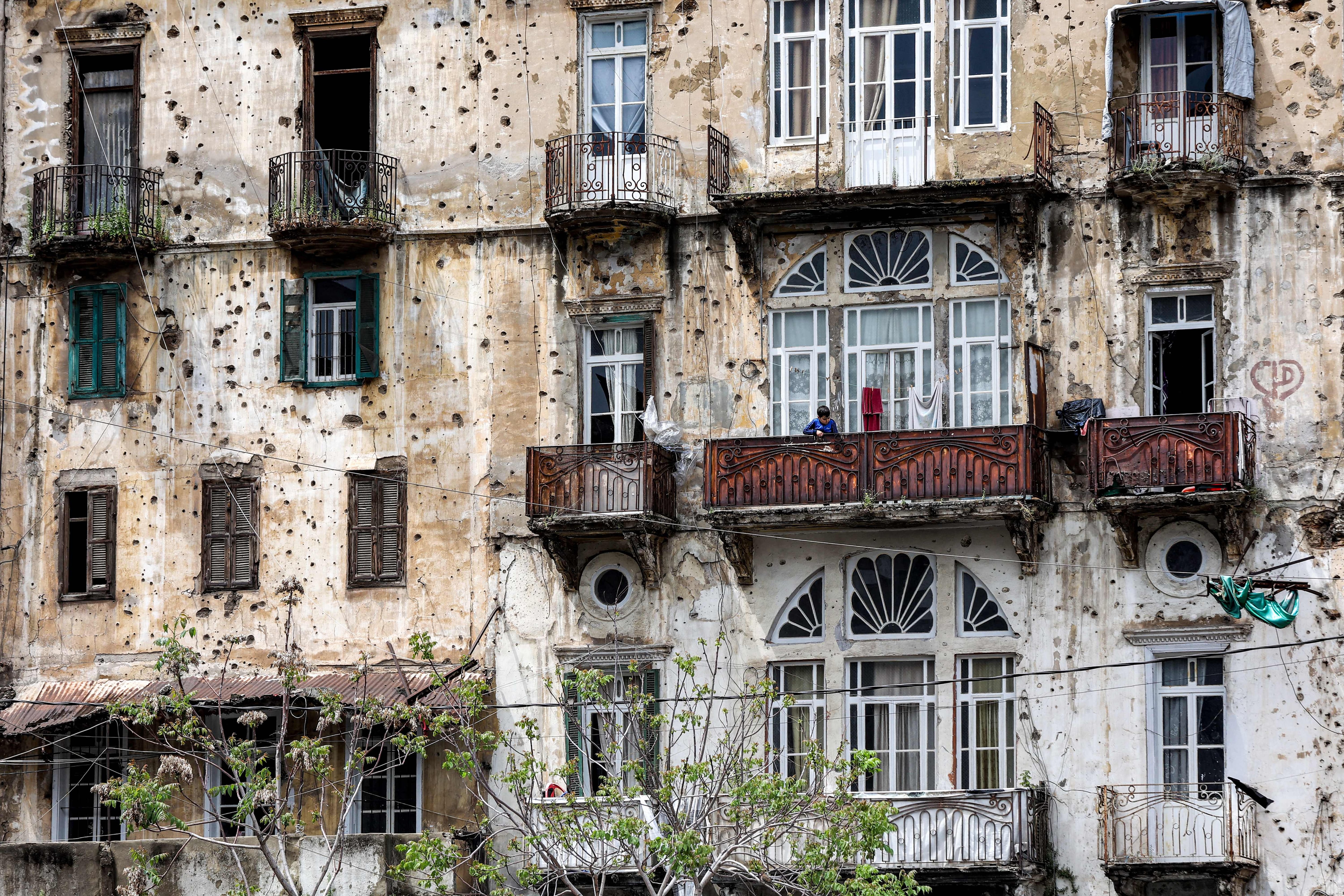 A boy stands on the balcony of a building ravaged by Lebanon's civil war in Beirut's southern Shayah district. The Lebanese civil war broke out on April 13, 1975, and ended in 1990 with the Taef agreement. Photograph: Anwar Amro/AFP via Getty Images