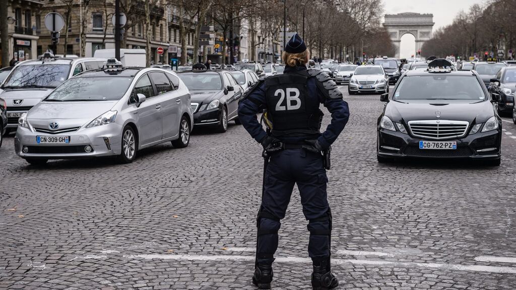 A police officer stands in front of French taxis blockading a Parisian street during a protest against Uber this week. Photograph: EPA/CHRISTOPHE PETIT TESSON