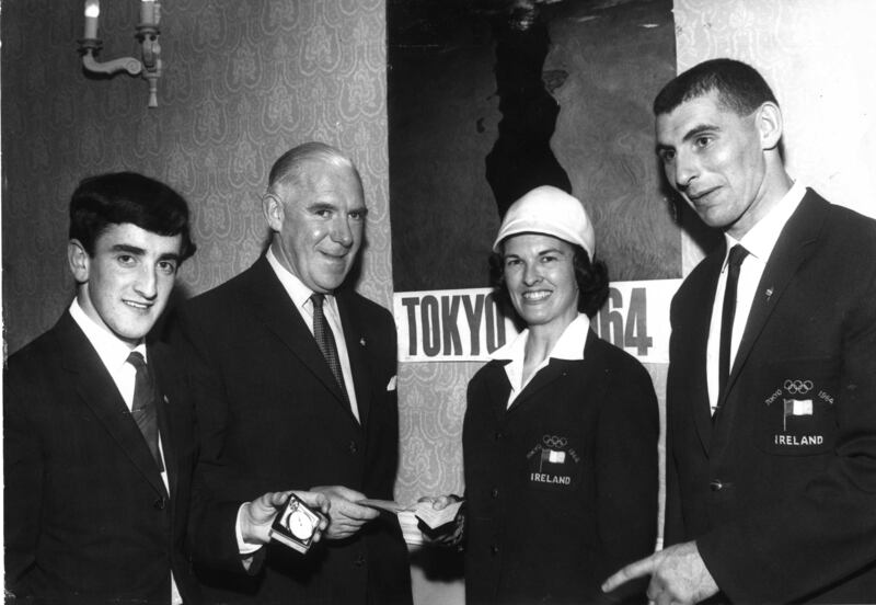 William Hammond, managing director, Smyth and Co, Balbriggan, presents a cheque for £100 to athlete Maeve Kyle towards her fare to the 1964 Olympic Games in Tokyo, along with, left, Michael Gibney, who presented a stop watch to the Irish team, and Irish judo Olympic contestant John Ryan. Photograph: Dermot Barry/The Irish Times