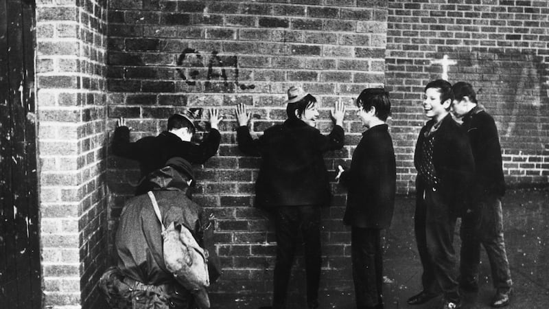 Schoolboys giggling while a soldier searches them in a street in the Ardoyne area of Belfast in 1971. Photograph: Keystone/ Getty Images )