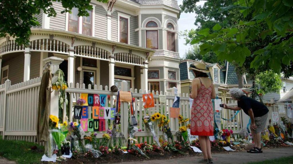 ‘Millions of strangers found themselves “devastated” and “bereft” at the news of Robin Williams’s death’. Above, a woman looks at an impromptu memorial to Robin Williams outside the house used in Mork and Mindy in Boulder, Colorado. Photograph: Rick Wilking/Reuters