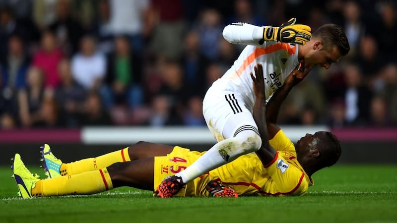 Mario Balotelli of Liverpool and Adrian of West Ham clash during the Barclays Premier League match at Boleyn Ground. Photograph: Mike Hewitt/Getty Images