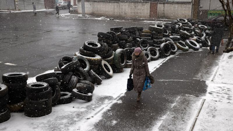 A woman walks past a roadblock in Mykolaiv. Photograph: Tyler Hicks/The New York Times