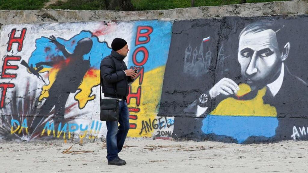 A man looks at graffiti in Odessa produced to support the territorial integrity of Ukraine and to protest Russia’s annexation of Crimea. The graffiti depicts Russian president Vladimir Putin and reads: “No to war; yes to peace!” Photograph: Reuters/Yevgeny Volokin