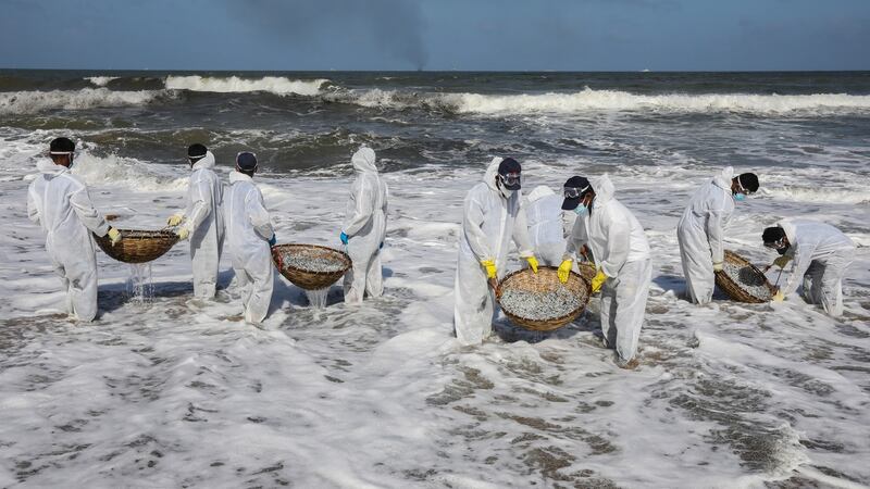 Sri Lanka Navy personnel clear the beach from debris and other materials that washed ashore on the beach of Negombo near Colombo. Photograph: Chamila Karunarathne/EPA