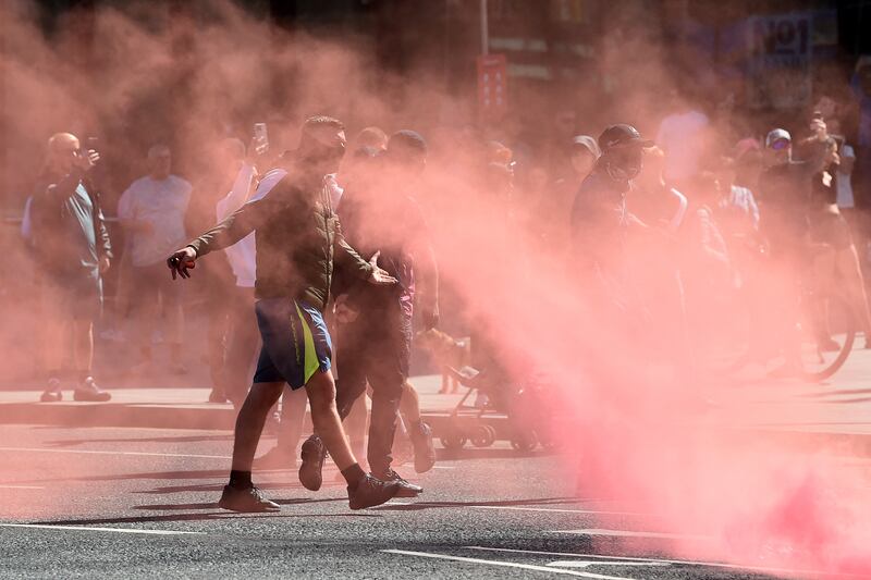 Protesters throw flares towards police officers in Liverpool. Photograph: Peter Powell/AFP via Getty Images