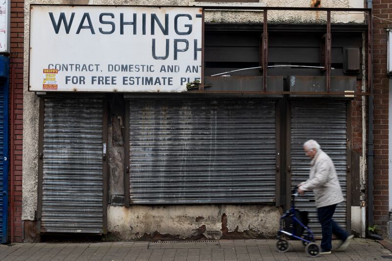 An elderly person walks past a shuttered shop in Runcorn town centre. Photograph: Ryan Jenkinson/Getty