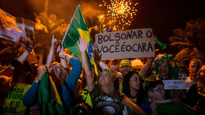 Supporters of Jair Bolsonaro, celebrate in front of his house in Rio de Janeiro. Photograph: Mauro Pimentel / AFP