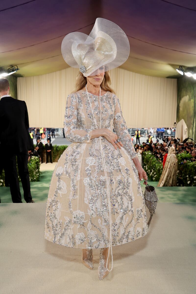 Sarah Jessica Parker wore a structured, subtle floral lace embellished dress by Quinn and topped off by a hat by Philip Treacy. Photograph: Kevin Mazur/MG24/Getty Images