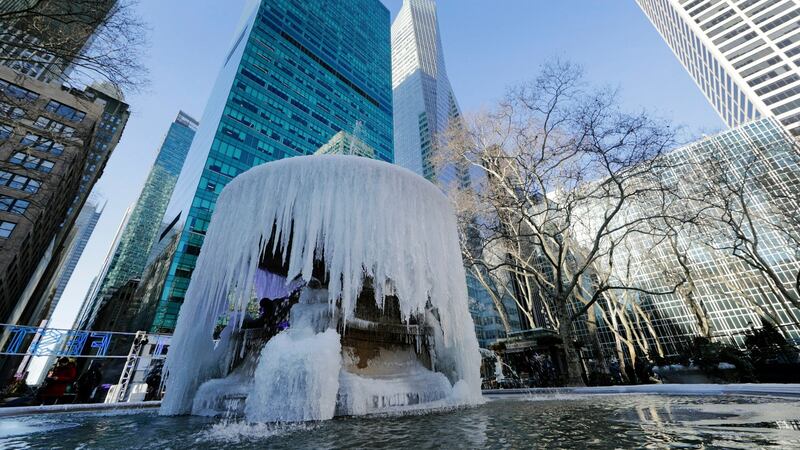 Pedestrians pass a frozen water fountain at Bryant Park on Thursday in New York. Photograph: Frank Franklin II/AP