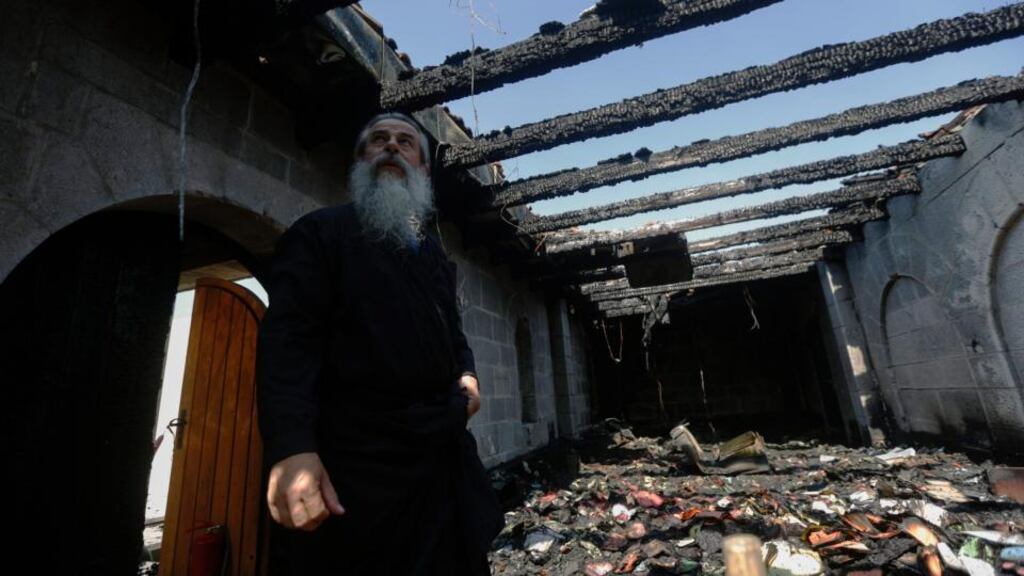 A cleric inspects the damage caused to the complex of the Church of Loaves and Fishes, on Tabgha, on the shores on the Sea of Galilee. An Israeli police spokesman said, that they are investigating the possibility that the attack was carried out by Jewish extremists. Photograph: Atef Safadi/EPA