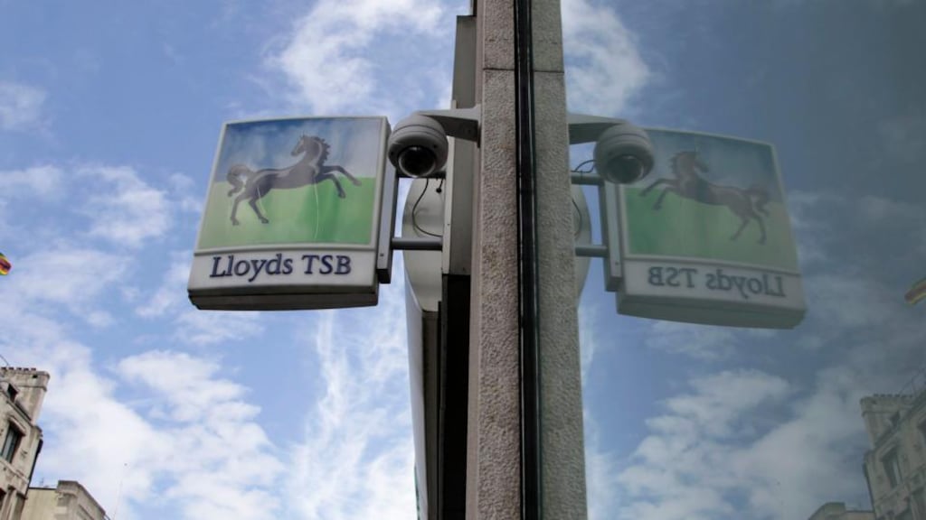 A sign from a branch of a Lloyds bank is reflected in a window in central London. Photograph: Stefan Wermuth/Reuters