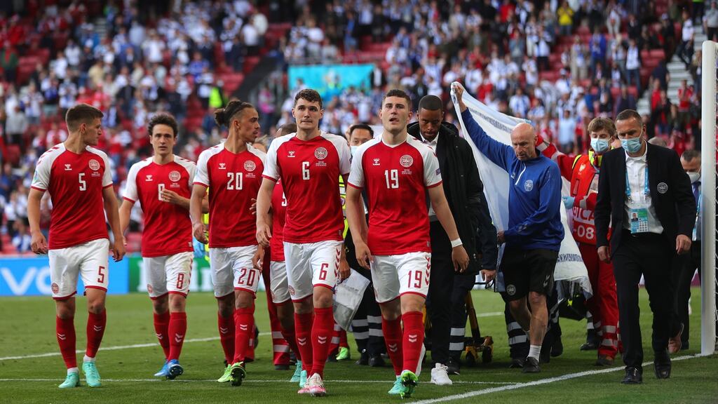 Denmark players escort their teammate Christian Eriksen as he is stretchered off the pitch in Copenhagen. Photograph: Friedemann Vogel/EPA