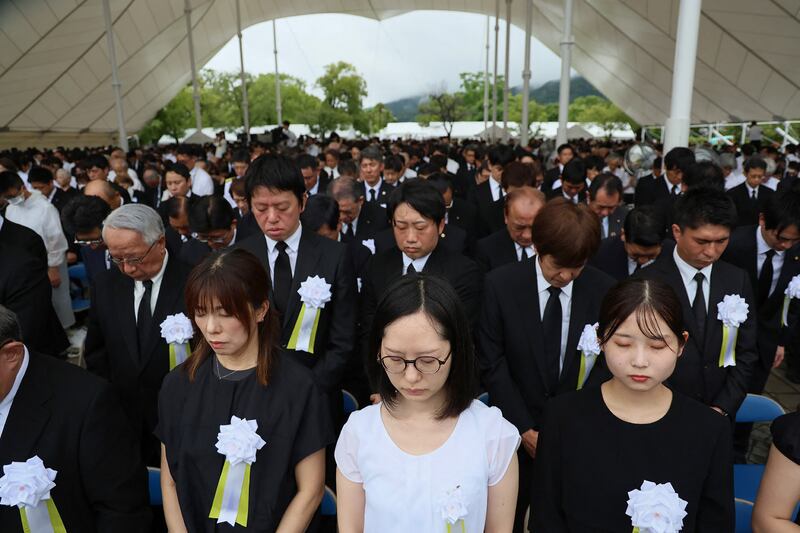 Participants take part in a moment of silence during the annual memorial ceremony. Photograph: Str/Jiji Press/AFP/Getty Images