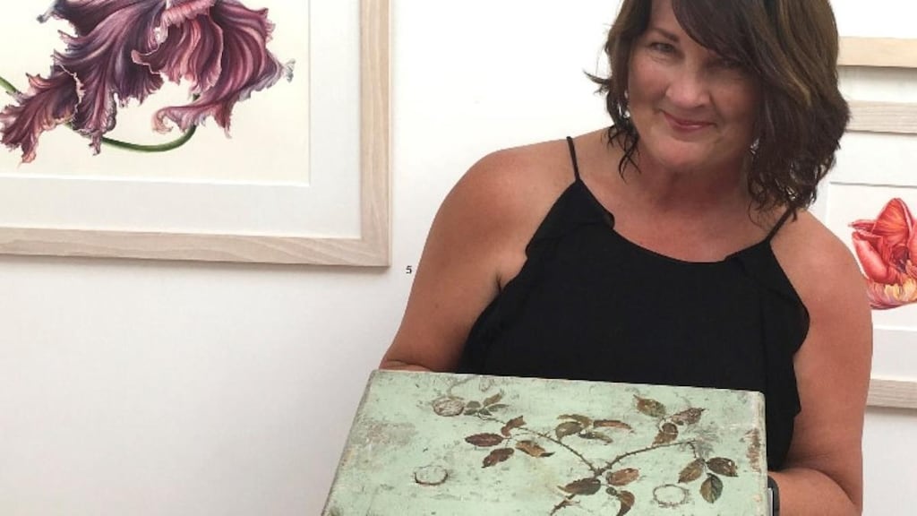 Mary Dillon with the stool painted by Charlotte Wheeler Cuffe, and her own work in the background
