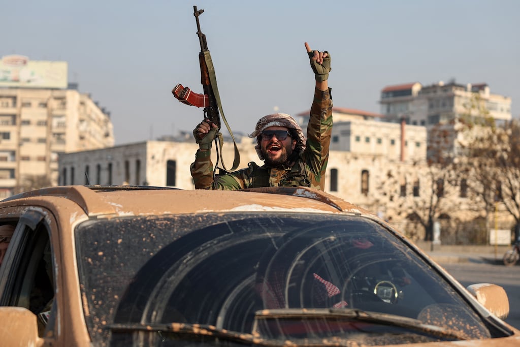 An anti-government fighter gestures from inside a vehicle patrolling the streets of Hama on Friday. Photograph: Omar Haj Kadour/AFP via Getty Images