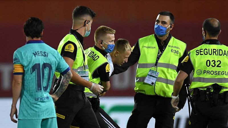 A member of the public is dragged away by security guards after invading the pitch during the La Liga match between RCD Mallorca and FC Barcelona at Estadio de Son Moix in Mallorca, Spain. Photograph: David Ramos/Getty Images