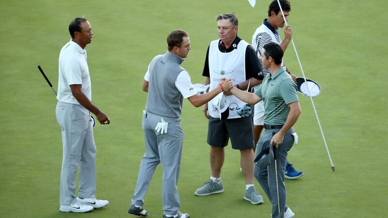 Tiger Woods, Justin Thomas, and Rory McIlroy of Northern Ireland shake hands after finishing their second rounds. Photo: Christian Petersen/Getty Images