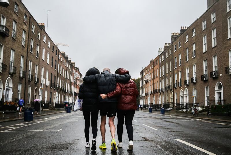 Colm Murray (centre) is helped home by his daughter Ciara and his wife Orla after the race. Photograph: Tom Maher