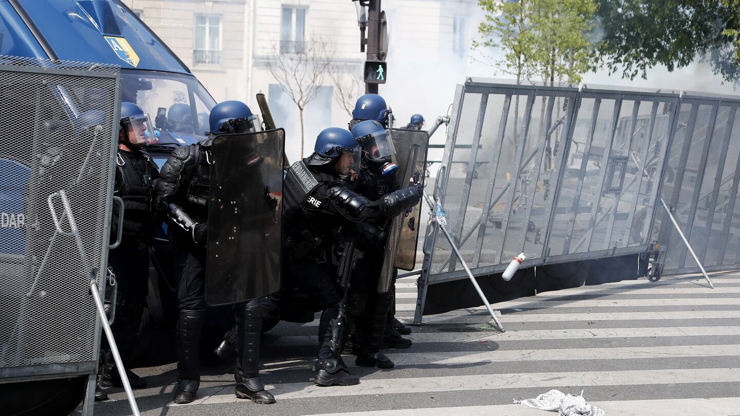 French riot police take cover during a demonstration in Paris. Photograph: Ian Langsdon
