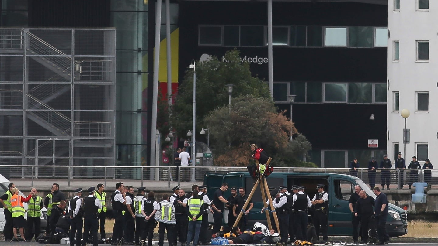 Emergency services surround protestors from the movement Black Lives Matter after they locked themselves to a tripod on the runway at London City Airport in London. Photograph: Getty
