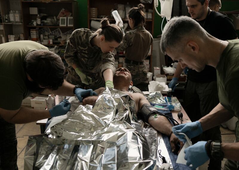 Doctors treating a Ukrainian soldier at a stabilisation point in the Zaporizhzhia region of Ukraine. Photograph: Emile Ducke/The New York Times