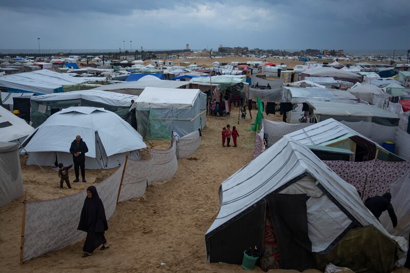 Palestinians displaced by the Israeli air and ground offensive on the Gaza Strip walk through a makeshift tent camp in Rafah. Photograph: Fatima Shbair/AP