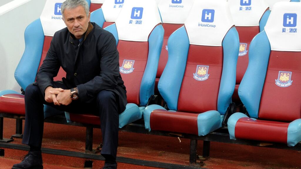 José Mourinho sits on his own before the start of the English Premier League game between West Ham United and Chelsea. Photograph: Hannah McKay/EPA
