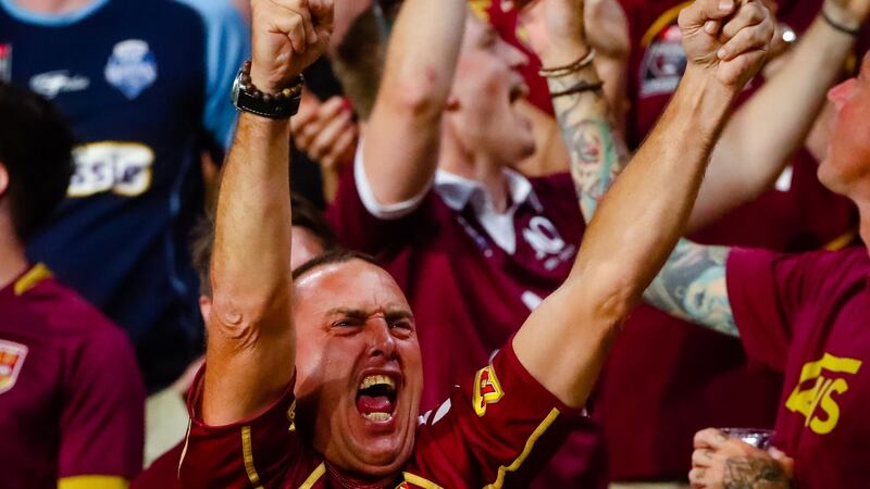 A Queensland fan celebrates during the match. Photo: Patrick Hamilton/AFP via Getty Images