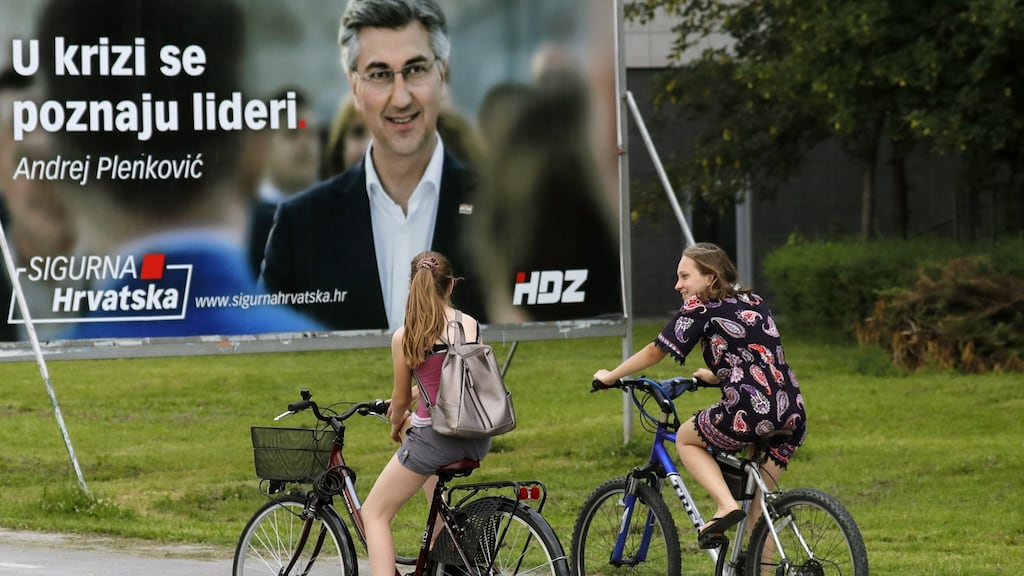 Cyclists in front an election poster of Croatian prime minister Andrej Plenkovic. He has been accused of endangering public health by calling the election during a pandemic. Photograph: Antonio Bat/EPA