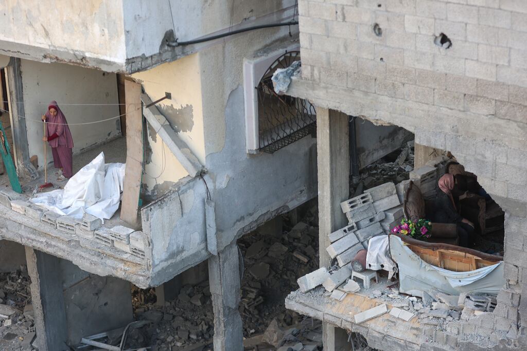 A Palestinian woman clears debris from her home following an Israeli strike on the Al-Shati refugee camp, west of Gaza City. Photograph: Omar Al-Qattaa/AFP