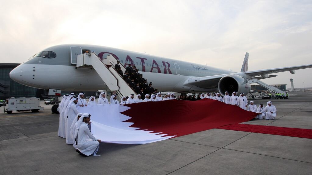 Qatar Airways staff hold a national flag in front of an Airbus A350-1000 at Hamad International Airport in Doha, Qatar. Photograph: Reuters