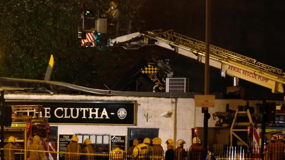 Rescue workers examine the wreckage of a police helicopter, which crashed onto the roof of the Clutha Vaults pub in Glasgow last night. Photograph: Russell Cheyne/Reuters