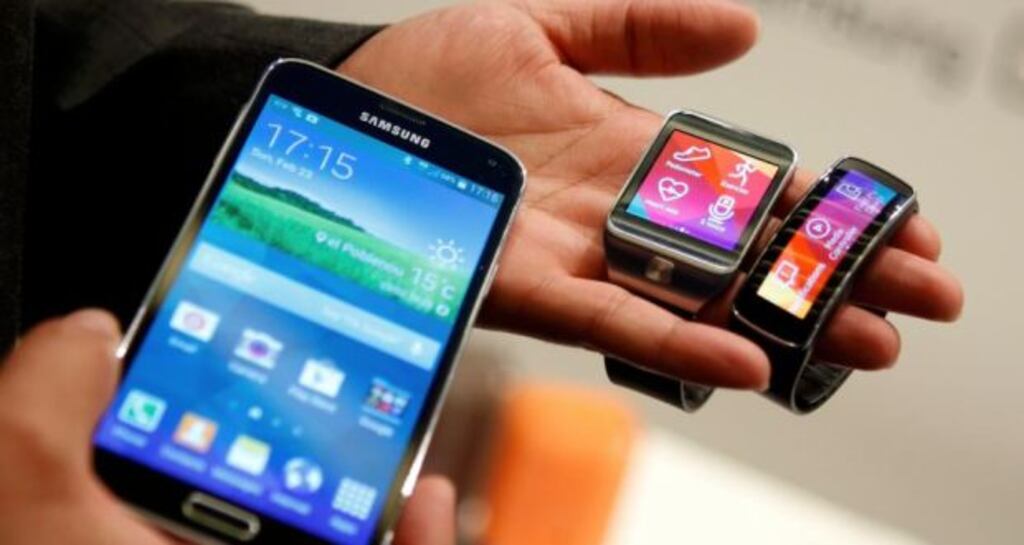 The new Samsung Galaxy S5 smartphone, Gear 2 smartwatch (centre) and Gear Fit fitness band are displayed. Photograph: Albert Gea/Reuters