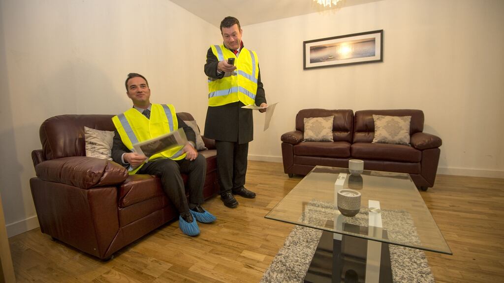 Alan Kelly (then minister for the environment, community and local government, standing) with John Lyons (then Labour TD) at the modular housing project in Ballymun, Dublin in February. People moved in last May. Photograph: Dara Mac Dónaill