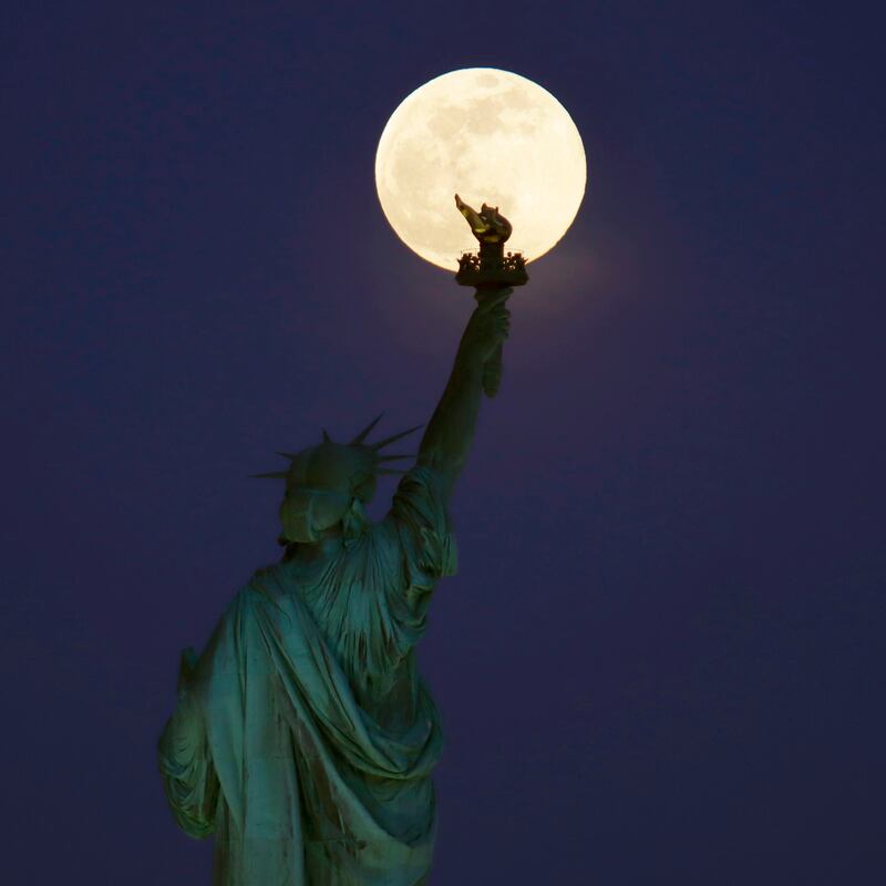 The super pink moon rises above the Statue of Liberty in New York City on April 26th, 2021 as seen from Jersey City, New Jersey. Photograph: Gary Hershorn/Getty