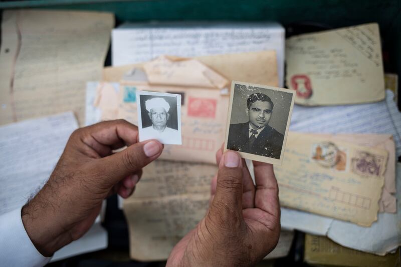 Saeed Anwar holds photographs of his father, Muhammad Anwar, left, and Piara Lal Duggal, whom his father helped shelter during partition, in Lahore, Pakistan. Photograph: Saiyna Bashir/The New York Times