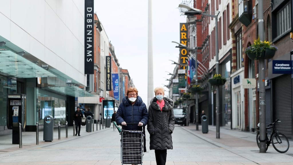 Two women wearing face masks make their way to the shops on an almost deserted Henry Street in Dublin’s city centre. Photograph:  Brian Lawless/PA Wire