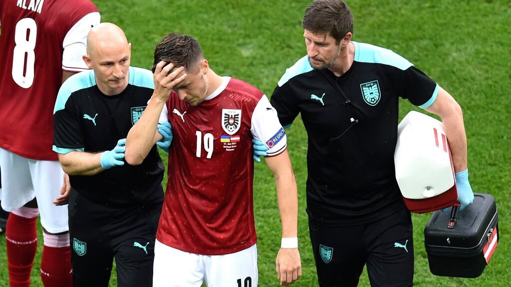 Austria’s Christoph Baumgartner is helped off the pitch after a clash of heads during their Euro 2020 match against Ukraine. Photo: Mihai Barbu/Pool Photo via AP