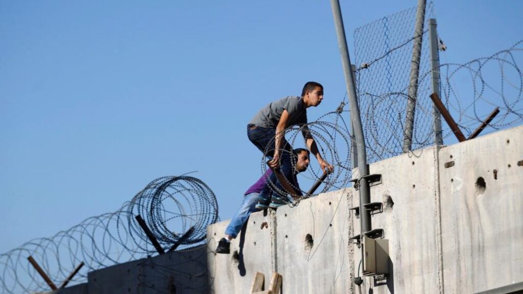 Palestinians not permitted by Israeli security forces to cross into Jerusalem from the West Bank due to an age limit, climb over a section of the controversial Israeli barrier as they try to make their way to attend the first Friday prayer of Ramadan in Jerusalem’s al-Aqsa mosque, in the village of Al-Ram, near Ramallah. Photograph: Mohamad Torokman/Reuters.