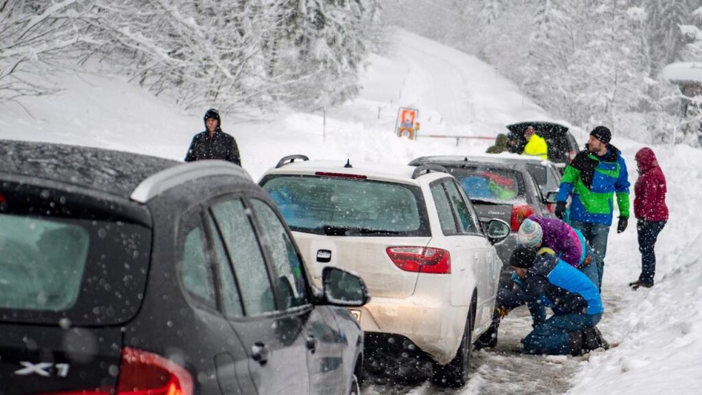 People putting  snow chains on their cars  during heavy snowfall near Untertauern, Austria. Photograph: . EPA/Christian Bruna