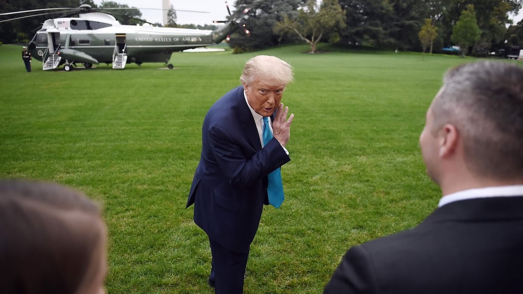 US president Donald Trump whispers to a White House staffer as he makes his way to board Marine One from the South Lawn of the White House on Saturday. Photograph: Olivier Douliery/AFP via Getty Images