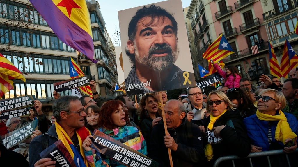 Demonstrators hold a picture of jailed Catalan separatist Jordi Cuixart and wave Catalan pro-independence Estelada flags during a protest against the trial of former Catalan separatist leaders in Barcelona. Photograph: Pau Barrena / AFP