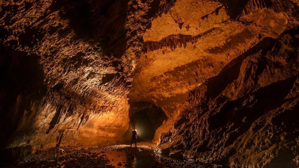 A member of the expedition team surveys unexplored passages in Hayamaene Cave, Papua New Guinea. Photograph: Jack Healy