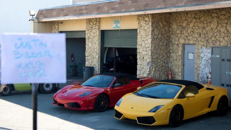 A sign that reads “Justin Bieber was here” stands in front of the two sports cars located in a police impound lot in Miami Beach, Florida today. Photograph: Gary I Rothsein/Reuters.