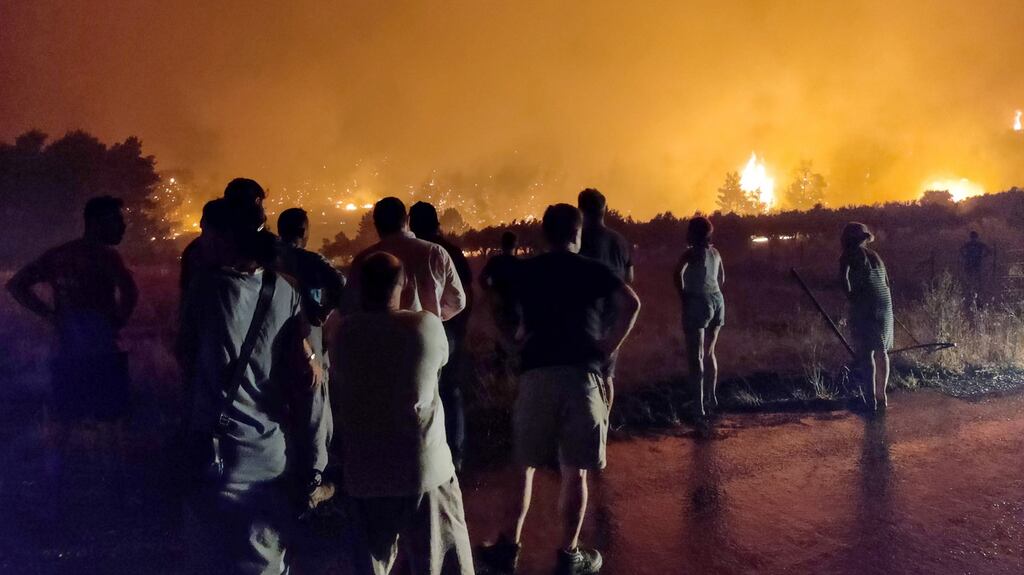 Residents watch a wildfire burning in the area of Limni in Evia island, eastern coast of Greece. Photograph: Panagiotis Kouros/EPA