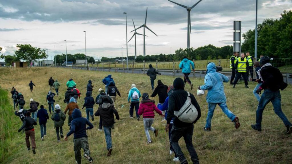 Migrants who managed to pass the police block on the Eurotunnel site race towards the boarding docks in Coquelles near Calais, northern France, on Wednesday. Photograph: AFP/Getty Images