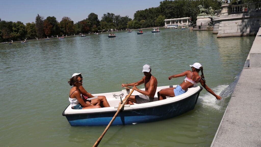A woman tries to cool off with water at the Retiro park, in Madrid, Spain. Photograph: Susana Vera/Reuters