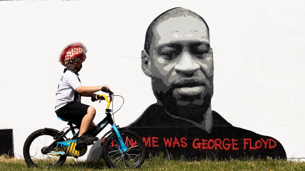 Four-year-old Cole Cronin cycles past a mural of George Floyd by artist Emmalene Blake in Kingswood, south Dublin. Photograph: Tom Honan