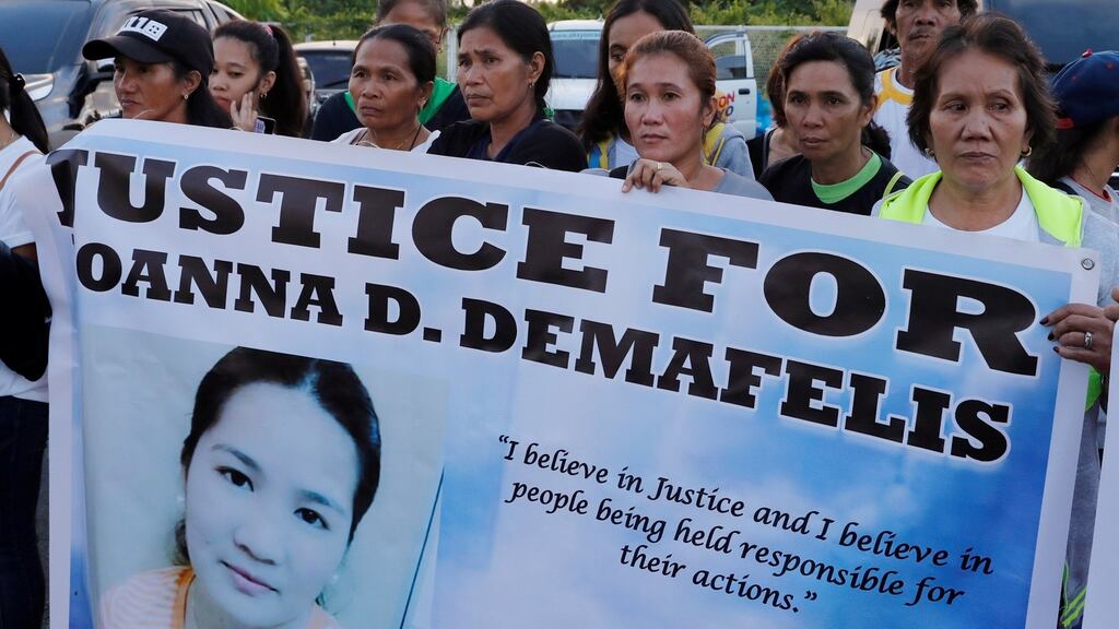 Residents display placards as they wait for the arrival of the body of Joanna Demafelis, the Filipina domestic worker who was killed and found inside a freezer in Kuwait, in her hometown in Iloilo province in the Philippines. Photograph: Reuters